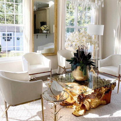 Delaney gold vase with multiple stems of Phalaenopsis orchids and succulents