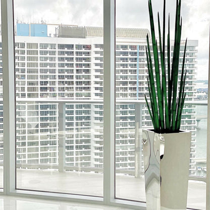 Stainless steel cube vase with snake grass
