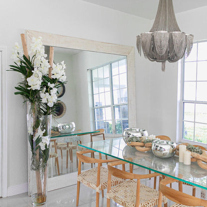 White Vanda orchids and driftwood in a large conical glass cylinder
